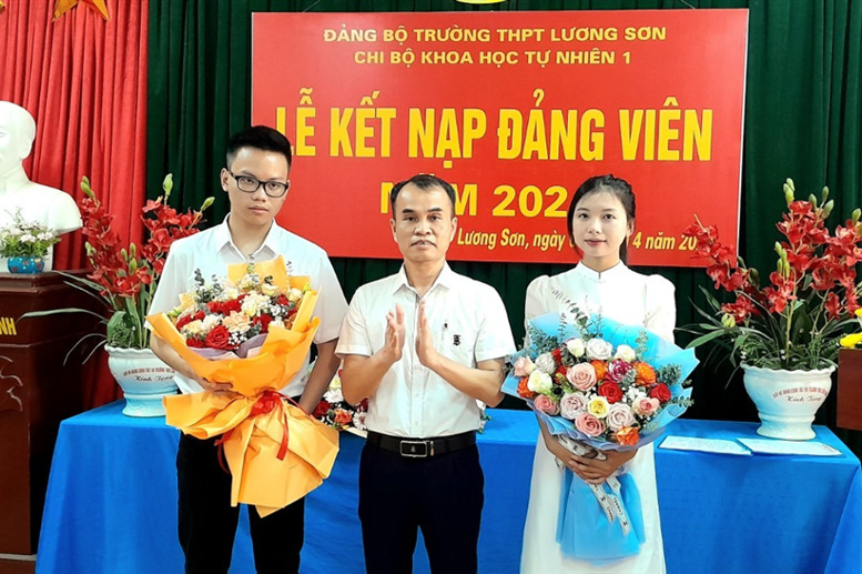 Đồng chí Phạm Ngọc Sơn - Phó Bí thư Đảng uỷ - Phó Hiệu trưởng nhà trường
                tặng hoa đảng viên mới Đinh Đức Thịnh và đảng viên mới Y Mai 